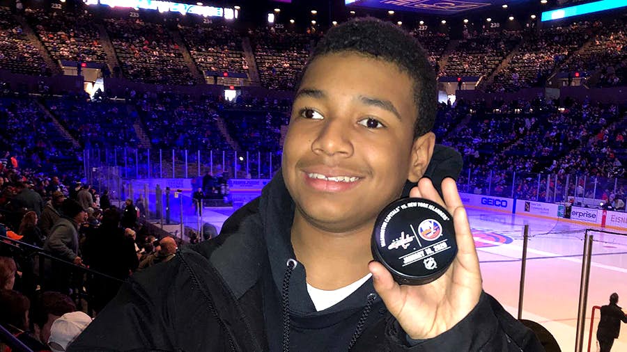 Starlight kid, Edwin Jr, age 12, diagnosed with cerebral palsy, with a commemorative puck